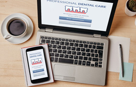 dental insurance forms on laptop and phone on desk