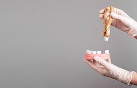 Wooden teeth and wooden pliers removing a tooth