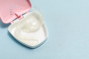 Clear aligners sitting in a pink plastic case